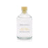 A wood smoke scented reed diffuser refill from the Home County Co is shown in its recyclable glass refill bottle.