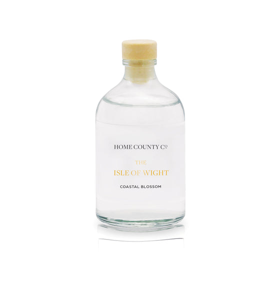 A coastal blossom scented reed diffuser refill from Home County Co. The eco friendly reed diffuser refill is shown in its recyclable glass bottle.