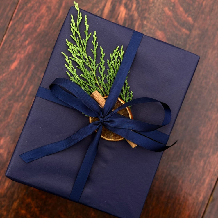 Home County Co. gift set with Christmas gift wrap - navy wrapping paper with a dried orange slice, cinnamon stick and a sprig of fir