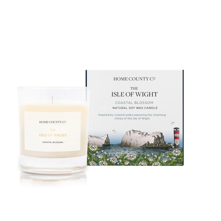 A coastal blossom scented soy wax candle inspired by the Isle of Wight is shown next to its sustainable candle box with coastal illustration
