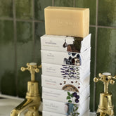 A stack of Home County Co. county soap bars is shown on a bathroom sink