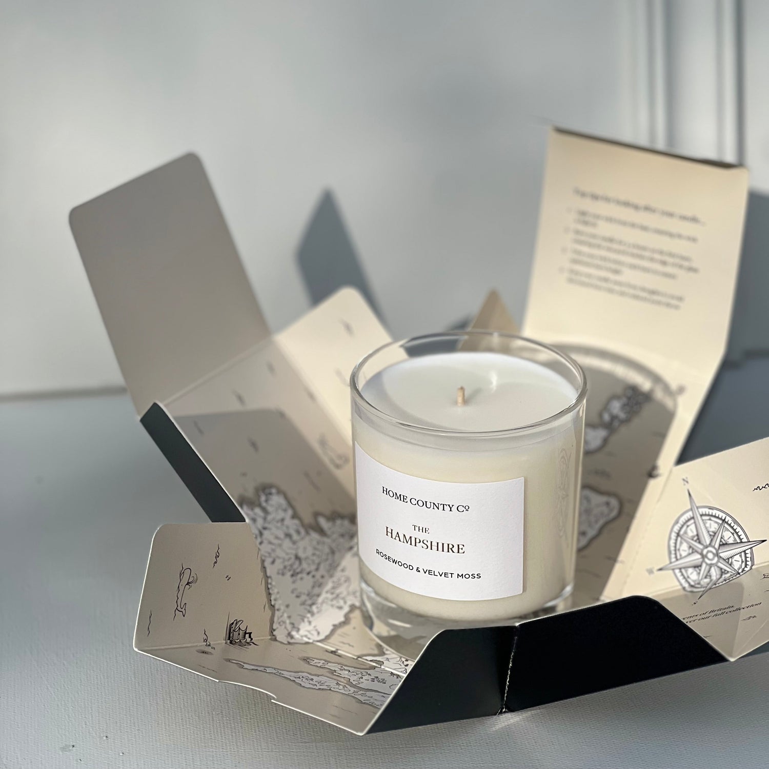 Candle in a decorative box with a label on a light background