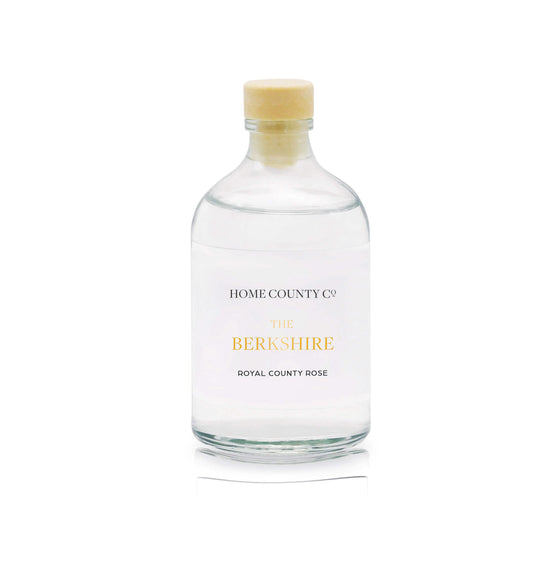 A royal county rose reed diffuser refill is shown in a recyclable glass bottle