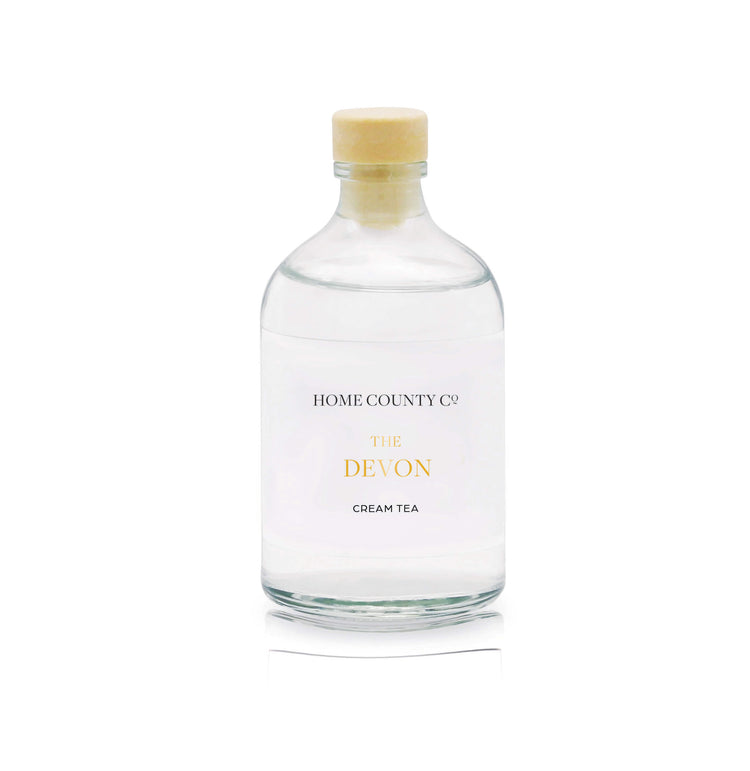 A cream tea reed diffuser refill is shown in a recyclable glass bottle