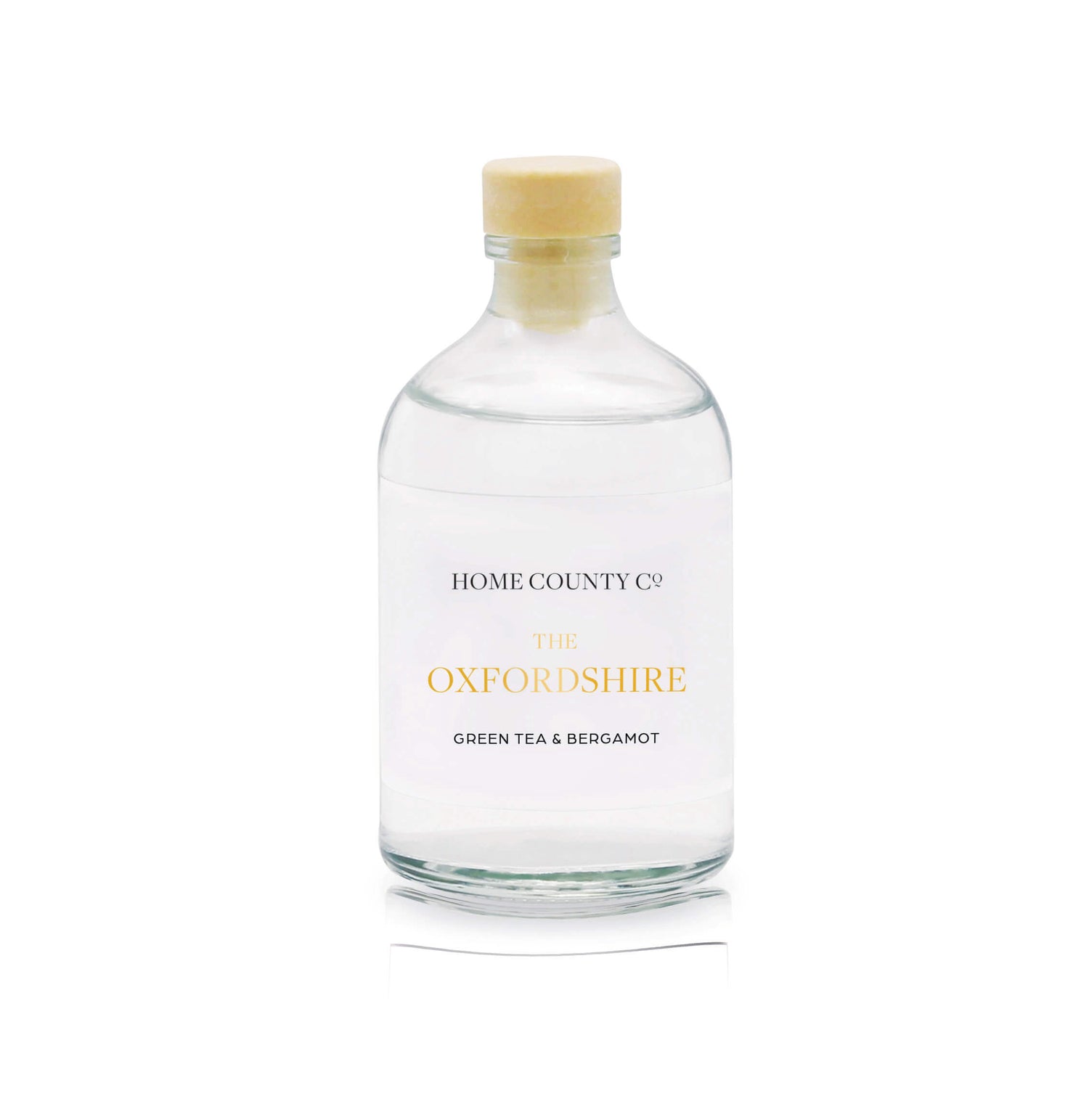 A green tea and bergamot reed diffuser refill is shown in a recyclable glass bottle