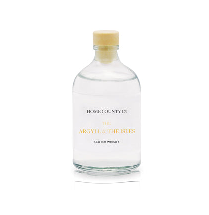 A scotch whisky scented reed diffuser refill from Home County Co. The eco friendly reed diffuser refill is shown in its recyclable glass bottle.