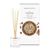 A Bakewell tart scented reed diffuser from Home County Co. The vegan friendly reed diffuser is shown next to the eco friendly reed diffuser box packaging.