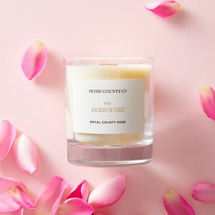 Home County Co. Berkshire rose scented candle shown with pink rose petals
