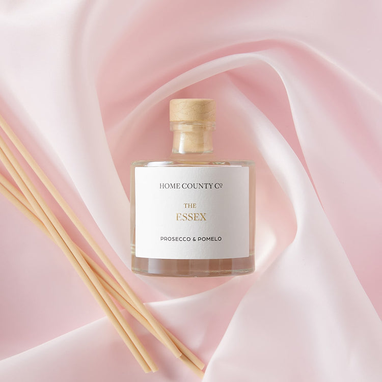 An Essex prosecco and pomelo scented reed diffuser from the Home County Co. is shown with its porex reeds