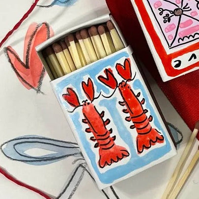 A mini matchbox, hand-painted by Eleanor Joanna with a lobster Valentine's design