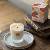 The English Heritage orchards candle is shown lit alongside its box