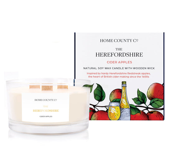 A cider apple scented 3 wick candle from the Home County Co. is shown next to its eco-friendly candle packaging box.