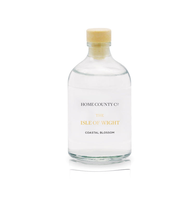 A coastal blossom scented reed diffuser refill from Home County Co. The eco friendly reed diffuser refill is shown in its recyclable glass bottle.