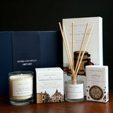 Home County Co. County Collection Gift Set shows an Edinburgh candle, argyll reed diffuser and deryshire soap bar in front of the luxury navy gift set box