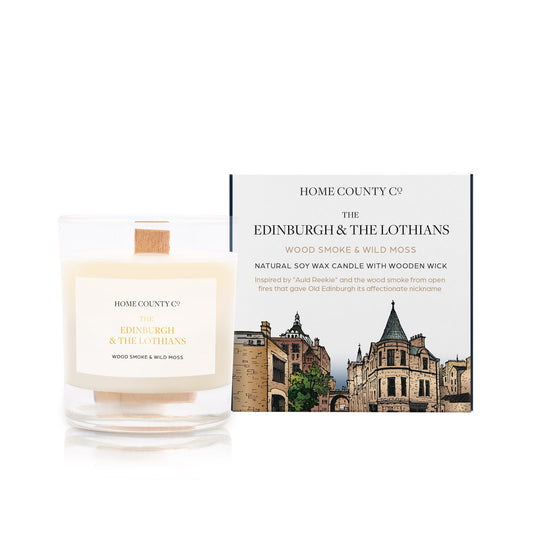 A wood smoke and wild moss scented candle from Home County Co. The wooden wick soy candle is shown next to the eco friendly candle box packaging which displays an illustration of Edinburgh&