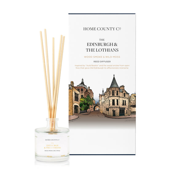 A woodsmoke and wild moss scented reed diffuser from Home County Co. The vegan friendly reed diffuser is shown next to the eco friendly reed diffuser box packaging which features an illustration of Edinburgh Old Town.