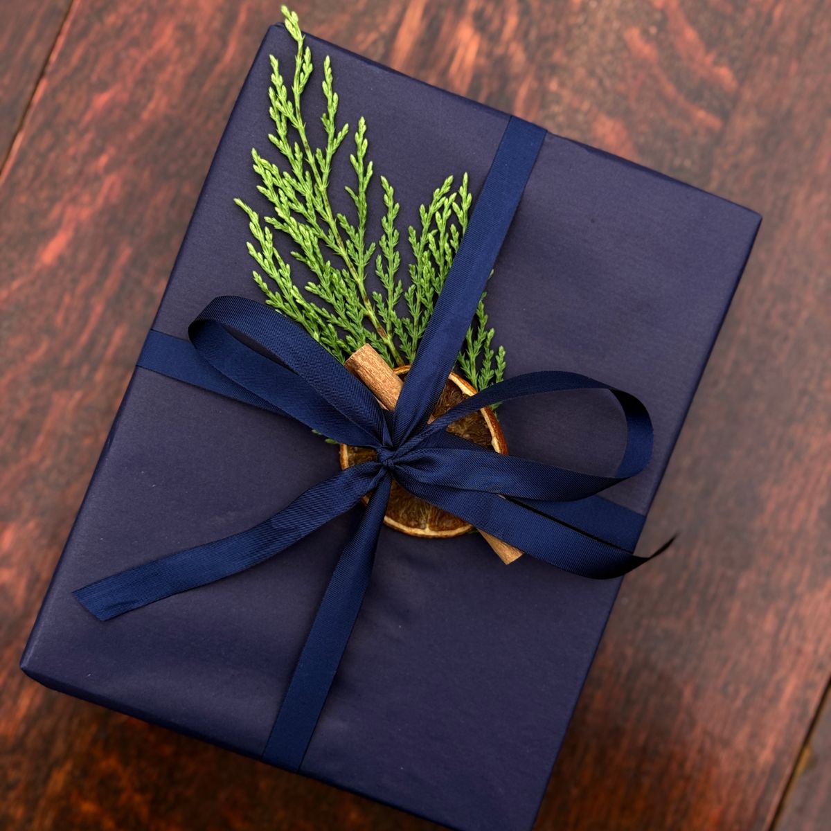 Home County Co. gift set with Christmas gift wrap - navy wrapping paper with a dried orange slice, cinnamon stick and a sprig of fir