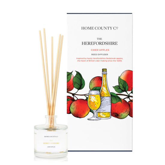 A cider apple scented reed diffuser from Home County Co. The vegan friendly reed diffuser is shown next to the eco friendly reed diffuser box packaging.