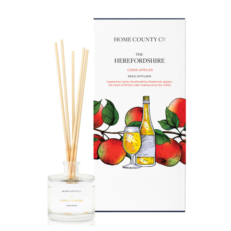 A cider apple scented reed diffuser from Home County Co. The vegan friendly reed diffuser is shown next to the eco friendly reed diffuser box packaging.