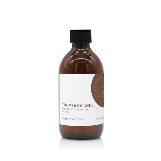A 300ml woody, masculine hand wash refill from the Home County Co. is shown in its recyclable amber glass hand wash bottle with recyclable hand wash refill cap.