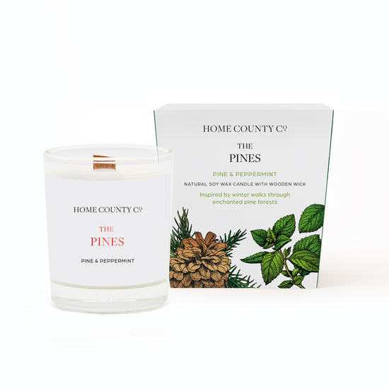 A Pine scented votive Christmas candle from the Home County Co. is shown in eco-friendly packaging