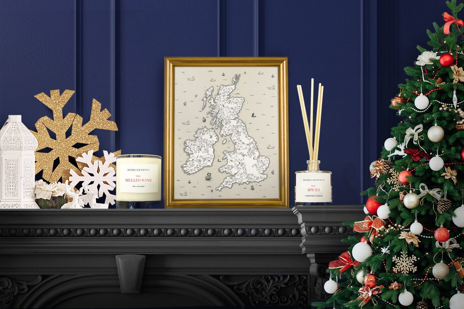 A Mulled Wine scented candle and a Cinnamon reed diffuser from the Home County Co are shown on a mantelpiece surrounded by Christmas decorations