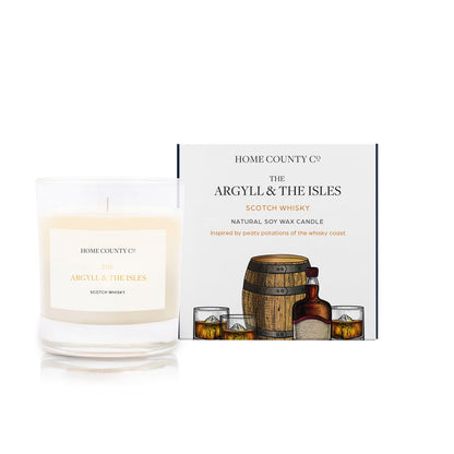 A scotch whisky scented soy wax candle inspired by Argyll and the Isles is shown next to its sustainable candle box with scotch whisky dram illustration