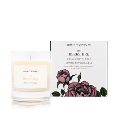 A rose scented soy wax candle inspired by Berkshire is shown next to its sustainable candle box with pink rose illustration