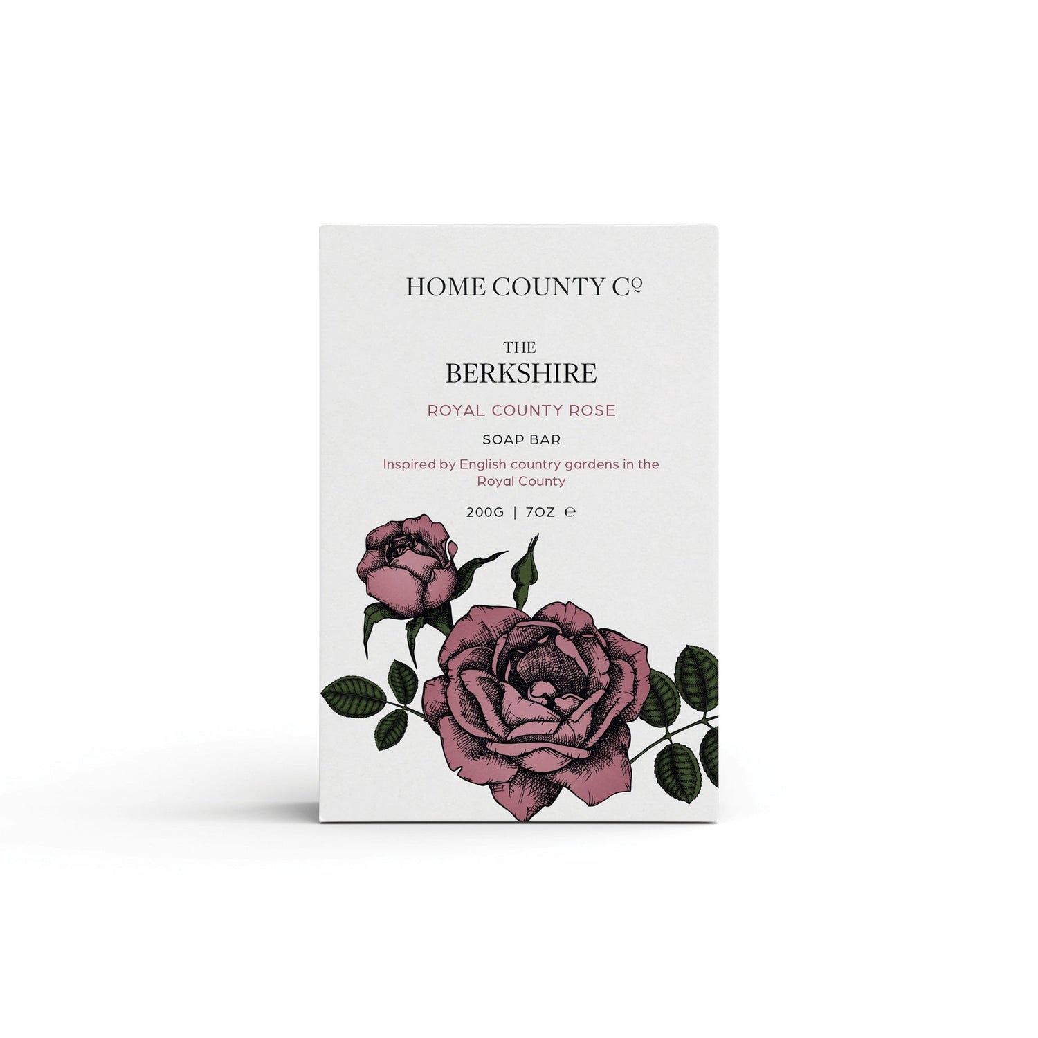 A rose scented natural soap bar from the Home County Co. is shown in its pink rose illustrated recyclable soap bar wrap