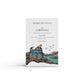 A rock salt and driftwood coastal scented natural soap bar from the Home County Co. is shown in its coastal illustrated recyclable soap bar wrap