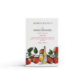 A cider apples scented natural soap bar from the Home County Co. is shown in its cider apple illustrated recyclable soap bar wrap