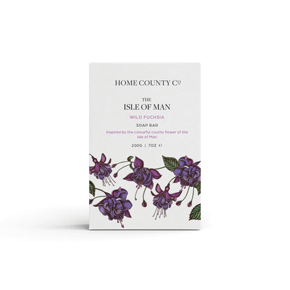 A wild fuchsia scented natural soap bar from the Home County Co. is shown in its fuchsia illustrated recyclable soap bar wrap