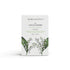 A lily of the valley scented natural soap bar from the Home County Co. is shown in its lily of the valley illustrated recyclable soap bar wrap