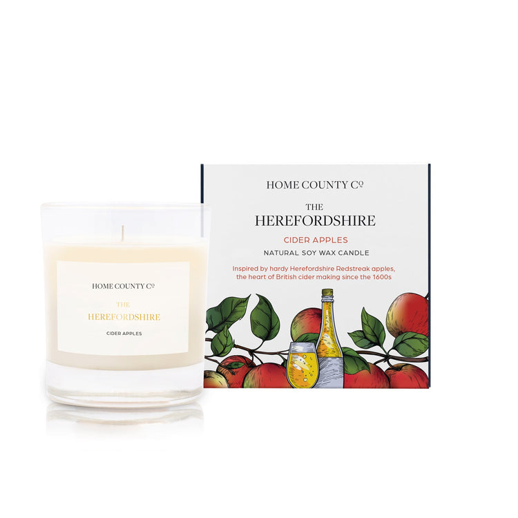 A cider apples scented soy wax candle inspired by Herefordshire is shown next to its sustainable candle box with cider apple illustration