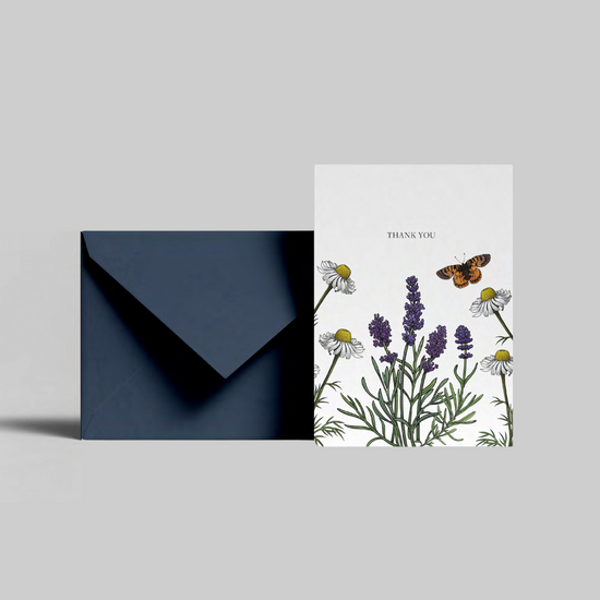 A lavender illustrated thank you card from the Home County Co. is shown with its navy envelope.