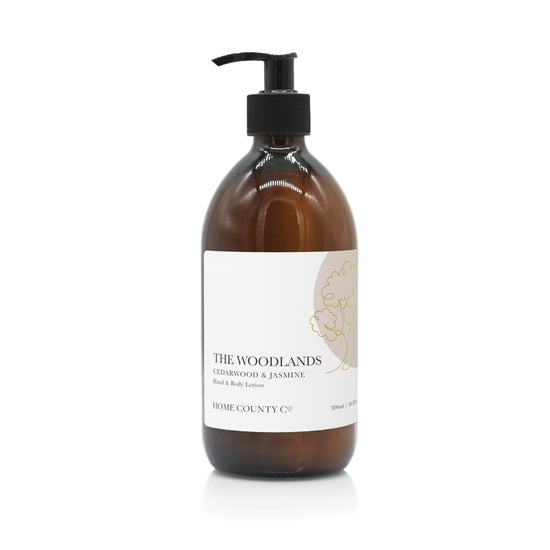 A 300ml woody scented hand and body lotion from the Home County Co. is shown in its recyclable amber glass bottle