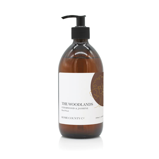 A 500ml woody scented liquid hand wash from the Home County Co. is shown in its recyclable amber glass hand wash bottle.