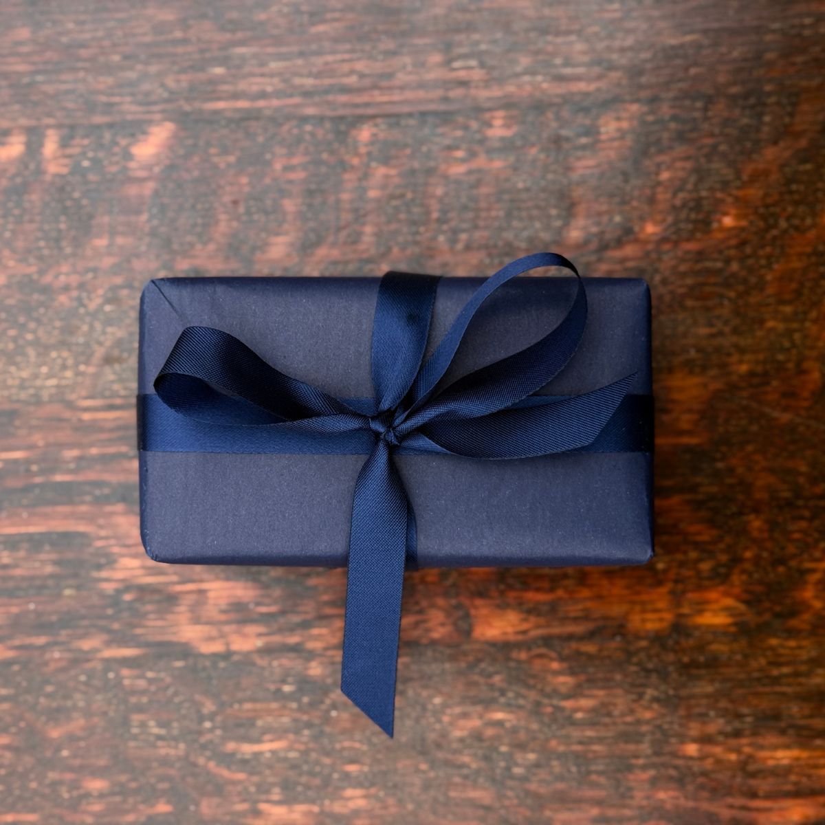A Home County Co. soap bar is shown with luxury gift wrap - navy wrapping paper with navy ribbon