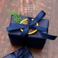 A Home County Co. soap bar bundle is shown with Christmas gift wrap - navy wrapping paper with navy ribbon and a dried orange slice and Christmas foliage