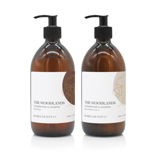 A 300ml woody cedarwood and jasmine scented hand wash and lotion duo from the Home County Co. is shown in eco-friendly amber glass bottles