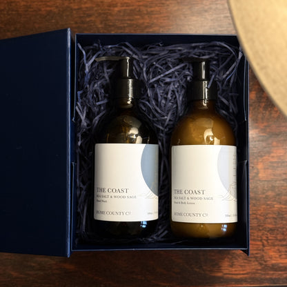 The Coast Sea Salt and Wood Sage scented hand soap and lotion gift set is shown in the open gift box on a table