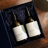 The Orchards Fresh Fig and Apples liquid hand wash and lotion gift set is shown with the amber glass bottles in an open gift box on a table.