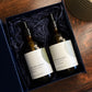 The Orchards Fresh Fig and Apples liquid hand wash and lotion gift set is shown with the amber glass bottles in an open gift box on a table.