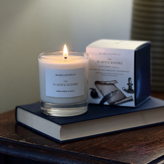 Warwickshire candle in a glass holder on a book with a blurred background