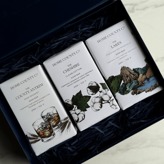 Home County Co. Trio of Soaps gift set shows 3 county-inspired soap bars in a luxury navy gift box with navy shredded paper