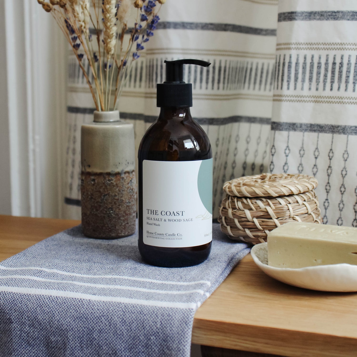 A 300ml coastal sea salt and wood sage liquid hand wash from the Home County Co. is shown in a bathroom