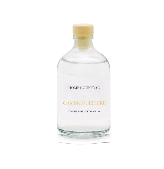 A cassis and black vanilla reed diffuser refill is shown in a recyclable glass bottle