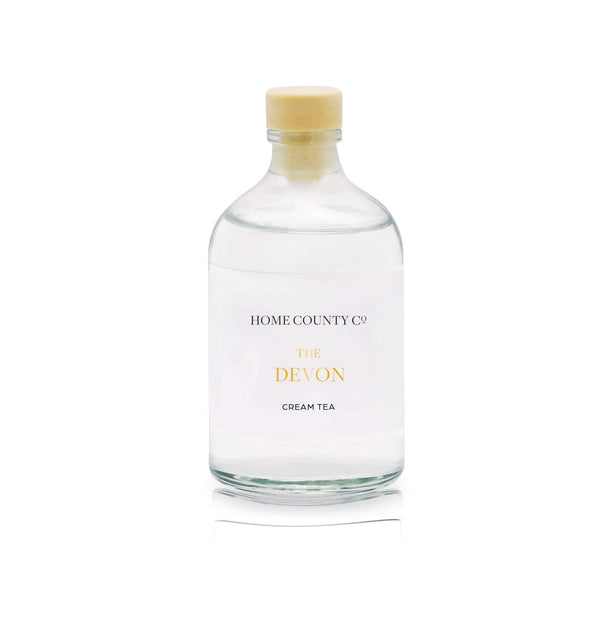 A cream tea reed diffuser refill is shown in a recyclable glass bottle