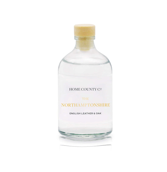 A English leather and oak reed diffuser refill is shown in a recyclable glass bottle