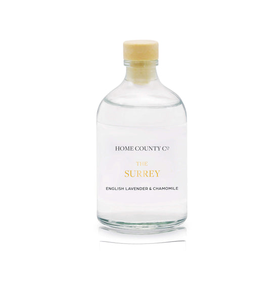 An English lavender and chamomile reed diffuser refill is shown in a recyclable glass bottle